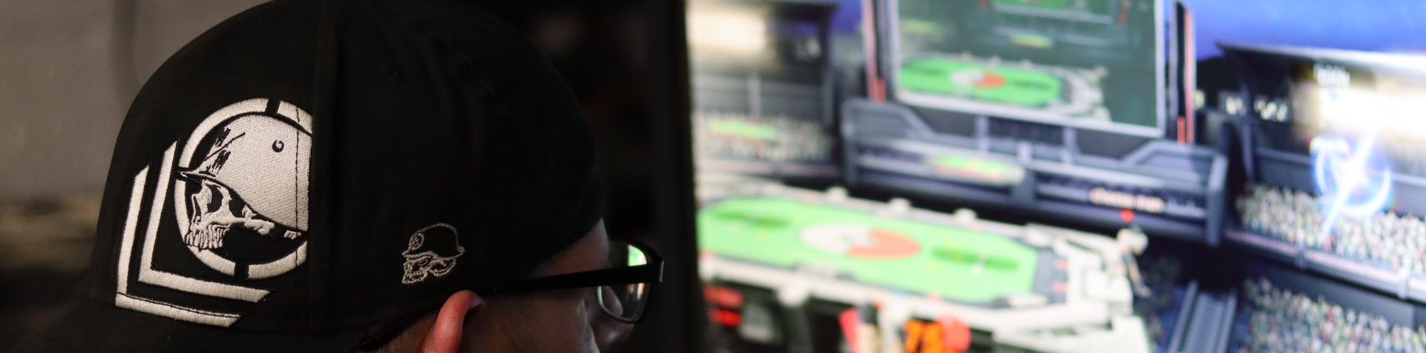 Person wearing a cap playing a video game on a computer screen.